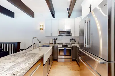 a kitchen with white cabinets and stainless steel appliances at Maison de Montagne in Incline Village
