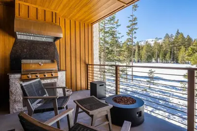 a screened in porch with a grill and a table and chairs at Obsidian 300 in Mammoth Lakes