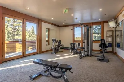a gym with several exercise equipment in a room with windows at Obsidian 300 in Mammoth Lakes