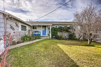 a white house with a blue door and a yard at 1 Mi to Main Street Sutter Creek Poolside Oasis! in Sutter Creek