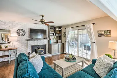 a living room with a blue couch and a fireplace at 1 Mi to Main Street Sutter Creek Poolside Oasis! in Sutter Creek