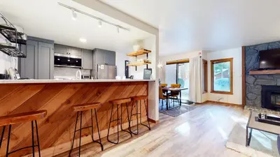 a kitchen and living room with a bar and a fireplace at Snowcreek I #11 condo in Mammoth Lakes
