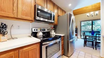 a kitchen with a refrigerator and a stove top oven at Snowcreek I #28 condo in Mammoth Lakes