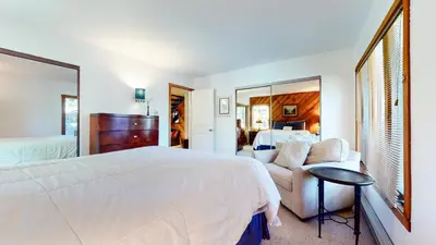 a bedroom with a large white bed and a couch at Snowcreek I #28 condo in Mammoth Lakes