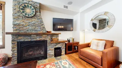 a living room with a fireplace and a chair at Woodwinds #1271 townhouse in Mammoth Lakes