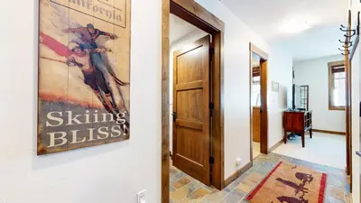 a hallway with a door and a painting on the wall at Woodwinds #1271 townhouse in Mammoth Lakes