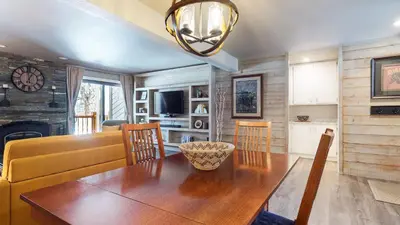a dining room and living room with a wooden table at Mammoth Creek #9 condo in Mammoth Lakes