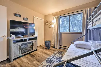 a bedroom with a bed and a large screen tv at Lakeside Groveland Home with Hot Tub, Near Yosemite in Groveland