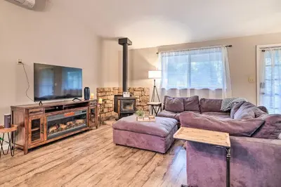 a living room with a couch and a tv and a fireplace at Lakeside Groveland Home with Hot Tub, Near Yosemite in Groveland