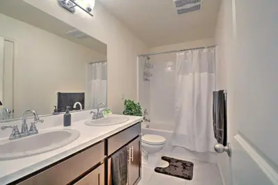 a bathroom with two sinks and a toilet and a shower at 4 Mi to City Center Family-Friendly Retreat! in Merced