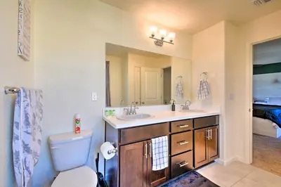 a bathroom with a sink and a toilet and a mirror at 4 Mi to City Center Family-Friendly Retreat! in Merced