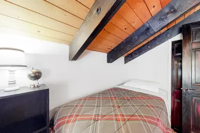a bedroom with a bed and a wooden ceiling at Back Country Basecamp in Stateline