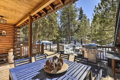 a wooden deck with a table and a grill at Dog-Friendly Kings Beach Log Cabin with Hot Tub! in Kings Beach