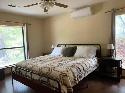 a bedroom with a bed and a ceiling fan at Yosemite Riverside Retreat with small beach access and air conditioning in Oakhurst