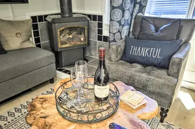 a wine bottle and glasses on a table in a living room at Walk to Lake Tahoe Cozy Zephyr Cove Cabin! in Zephyr Cove