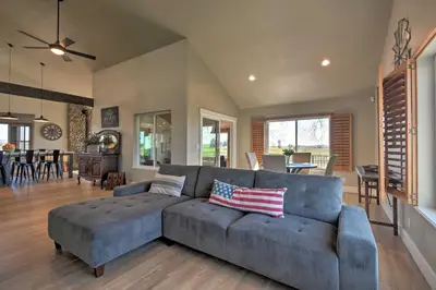 a living room with a blue couch and a dining room at Picturesque Farmhouse on Working Almond Ranch in Oakdale