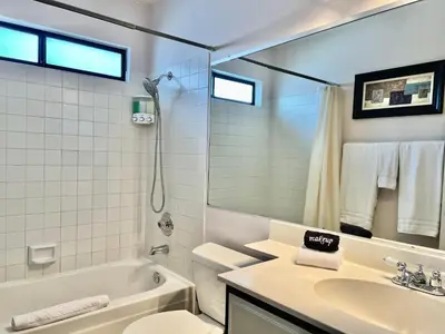 a bathroom with a sink and a toilet and a mirror at DT Reno - 4BR Home with Patio, BBQ Grill, Games Room in Reno