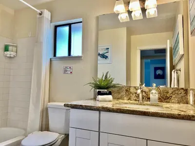 a bathroom with a sink and a toilet and a mirror at DT Reno - 4BR Home with Patio, BBQ Grill, Games Room in Reno