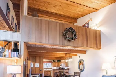 a living room with wooden ceilings and a dining room at Spacious Winterset 26 2 Bedrm Plus Loft 3 Full Bathrm Townhome Sleeps 8 Steps to Free Town Shuttle in Mammoth Lakes
