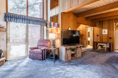 a living room with a chair and a flat screen tv at Spacious Winterset 26 2 Bedrm Plus Loft 3 Full Bathrm Townhome Sleeps 8 Steps to Free Town Shuttle in Mammoth Lakes