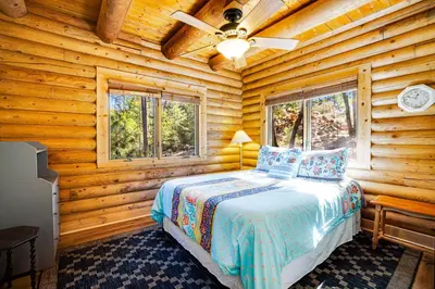 a bedroom with a bed in a log cabin at The Cub Inn in Groveland