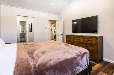 a bedroom with a large bed and a flat screen tv at Ski in Ski Out 3 Bedrm 3 Bathrm fully remodeled Sierra Megeve Condo Steps to Canyon Lodge Sleeps 8 in Mammoth Lakes