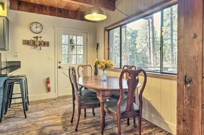 a kitchen and dining room with a wooden table and chairs at Walk Downtown Arnold Cabin with Large Deck! in Arnold