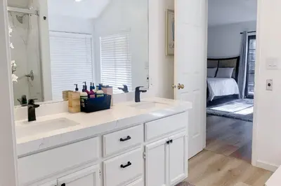 a white kitchen with a sink and a mirror at Fun In The Sun Cabin in Groveland
