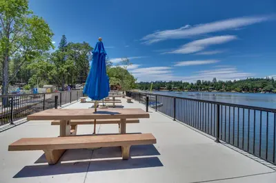 an umbrella and benches on a walkway next to the water at Fun In The Sun Cabin in Groveland