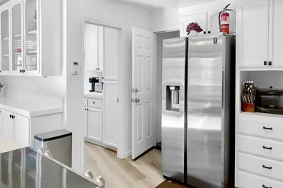 a kitchen with a stainless steel refrigerator and white cabinets at Fun In The Sun Cabin in Groveland
