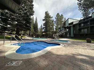 a swimming pool in a yard next to a building at St, Anton #54 condo in Mammoth Lakes