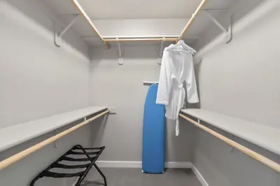 a walk in closet with blue and white shelves and a chair at Chic Apt w Jacuzzi, Pool, BBQ, & Mountain Views in Sparks