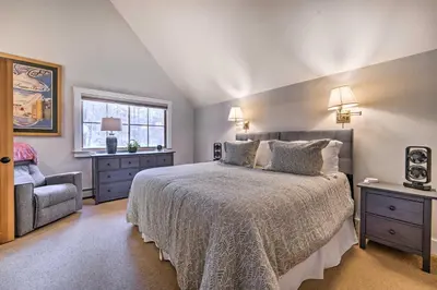 a bedroom with a bed and a chair and a window at Furnished Deck Cabin on Northstar Shuttle Route! in Truckee