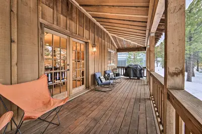 a porch of a wooden house with chairs on it at Furnished Deck Cabin on Northstar Shuttle Route! in Truckee