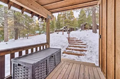 a wooden porch with a bench on a deck with snow at Furnished Deck Cabin on Northstar Shuttle Route! in Truckee
