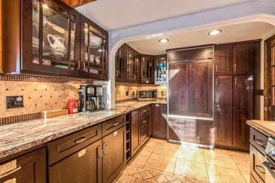 a large kitchen with wooden cabinets and a refrigerator at Red Oasis in Oakhurst