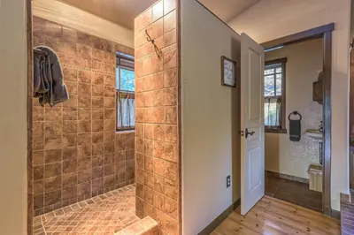 a bathroom with a shower with a stone wall at Red Oasis in Oakhurst