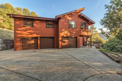 a house with two garage doors on a driveway at Red Oasis in Oakhurst