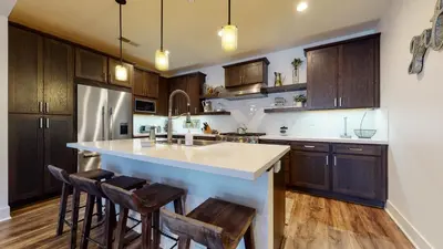 a kitchen with wooden cabinets and a large island with bar stools at Snowcreek VII #1403 condo in Mammoth Lakes