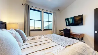 a bedroom with a bed with a television and a desk at Snowcreek VII #1403 condo in Mammoth Lakes