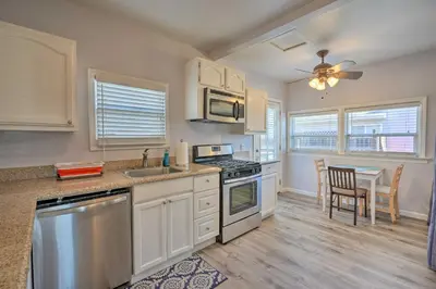 a kitchen with white cabinets and a table and a ceiling fan at Pet-Friendly Sacramento Home about 5 to Downtown! in Sacramento