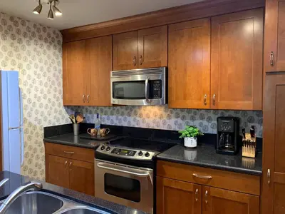 a kitchen with wooden cabinets and a stove and microwave at Woodsy retreat near Northstar & lake in Kings Beach