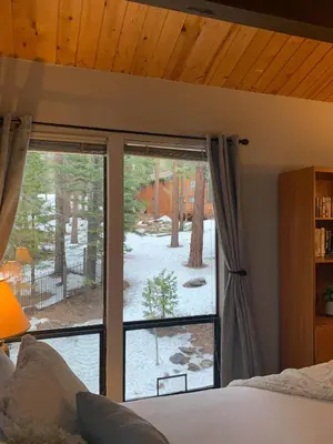 a bedroom with a large window with a view of a yard at Woodsy retreat near Northstar & lake in Kings Beach