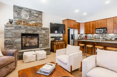 a kitchen and living room with a stone fireplace at Newly Updated Red Slate 4 is a 4 Bedrm 3 full Bathrm Townhome Close to Canyon Lodge That Sleeps 10 in Mammoth Lakes
