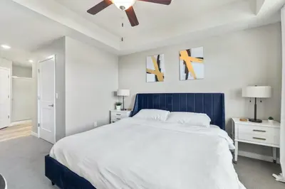 a bedroom with a large bed and a ceiling fan at Designer Apt with Jacuzzi, Pool & Mountain Views in Sparks