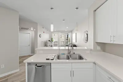 a white kitchen with a sink and a counter at Chic Apt with Jacuzzi, Pool Nr Casino & Shopping in Sparks