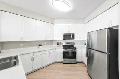 a kitchen with white cabinets and a stainless steel refrigerator at Designer Apt with Jacuzzi, Sky Lounge, Gym Access in Sparks