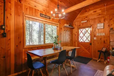 a dining room with a wooden table and chairs at 3 Mi to Big Trees State Park Cabin with Scenic Deck in Arnold