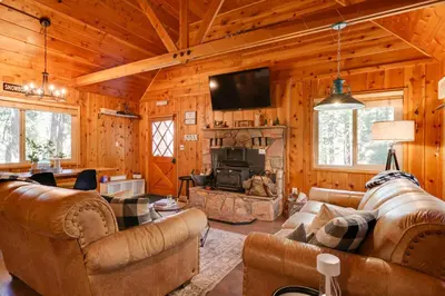 a living room with couches and a fireplace in a cabin at 3 Mi to Big Trees State Park Cabin with Scenic Deck in Arnold