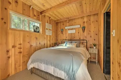 a bedroom with a bed in a wooden cabin at 3 Mi to Big Trees State Park Cabin with Scenic Deck in Arnold